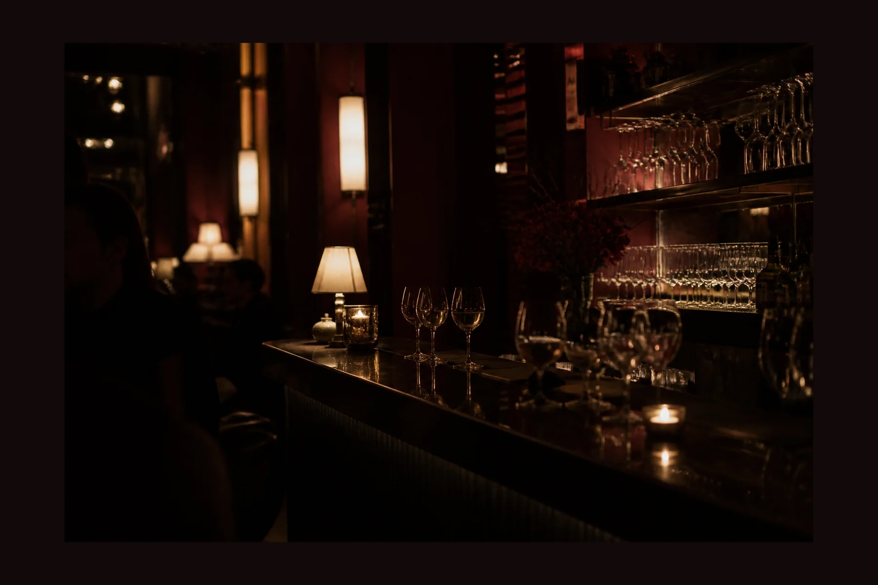 Dunkle Wine Bar mit Glasreflexionen und warmem Licht